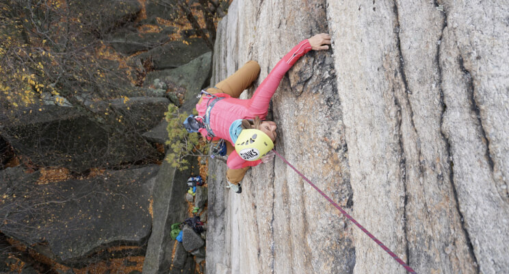 A female climber climbing on a crag.