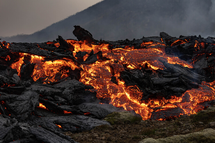 Icelandic volcanic eruption, showcasing vibrant lava streams and plumes of ash against a dramatic sky