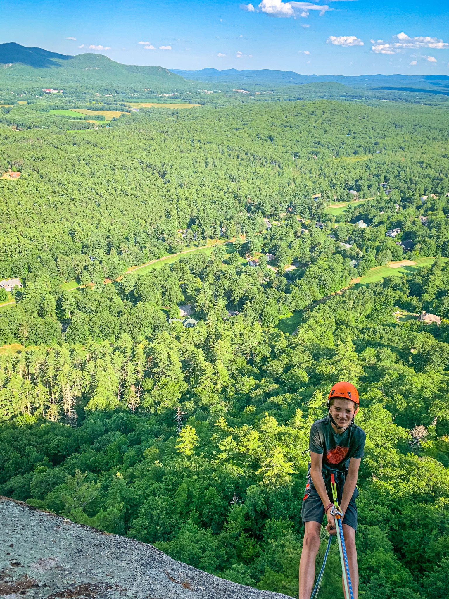 A young climber overlooking the forest in Acadia National Park