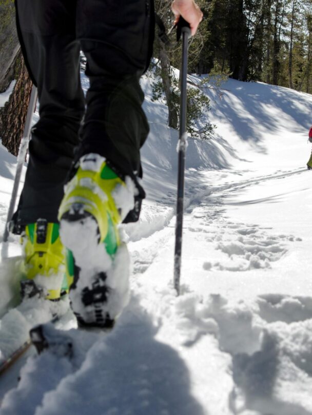 A skier skinning up a snow covered slope at sunrise in the Sierra Nevada near Lake Tahoe, California.