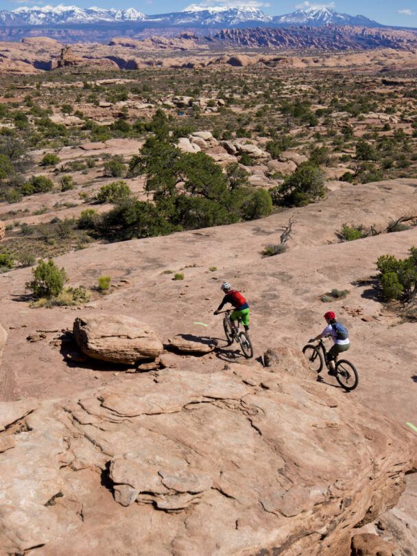 3 people riding a mountain bike in Moab, Utah