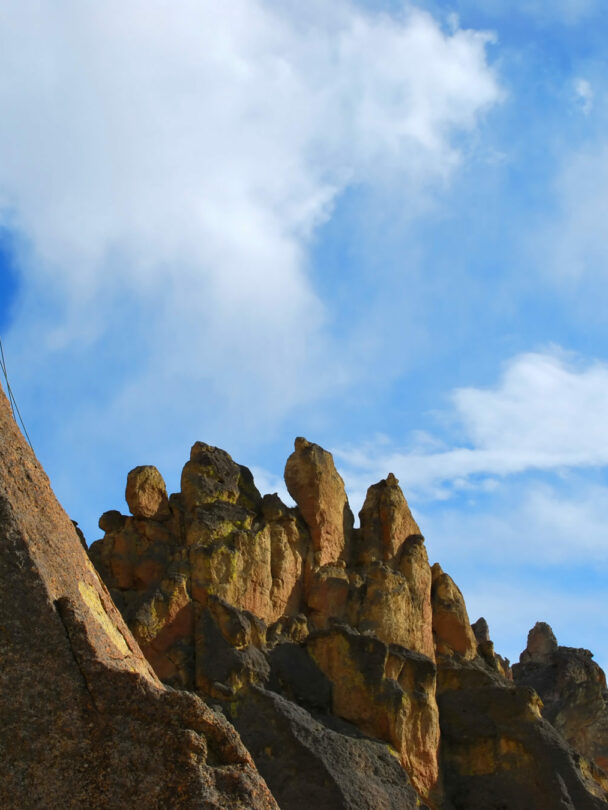 "A woman ascends a cliff at Smith Rock State Park, Oregon."