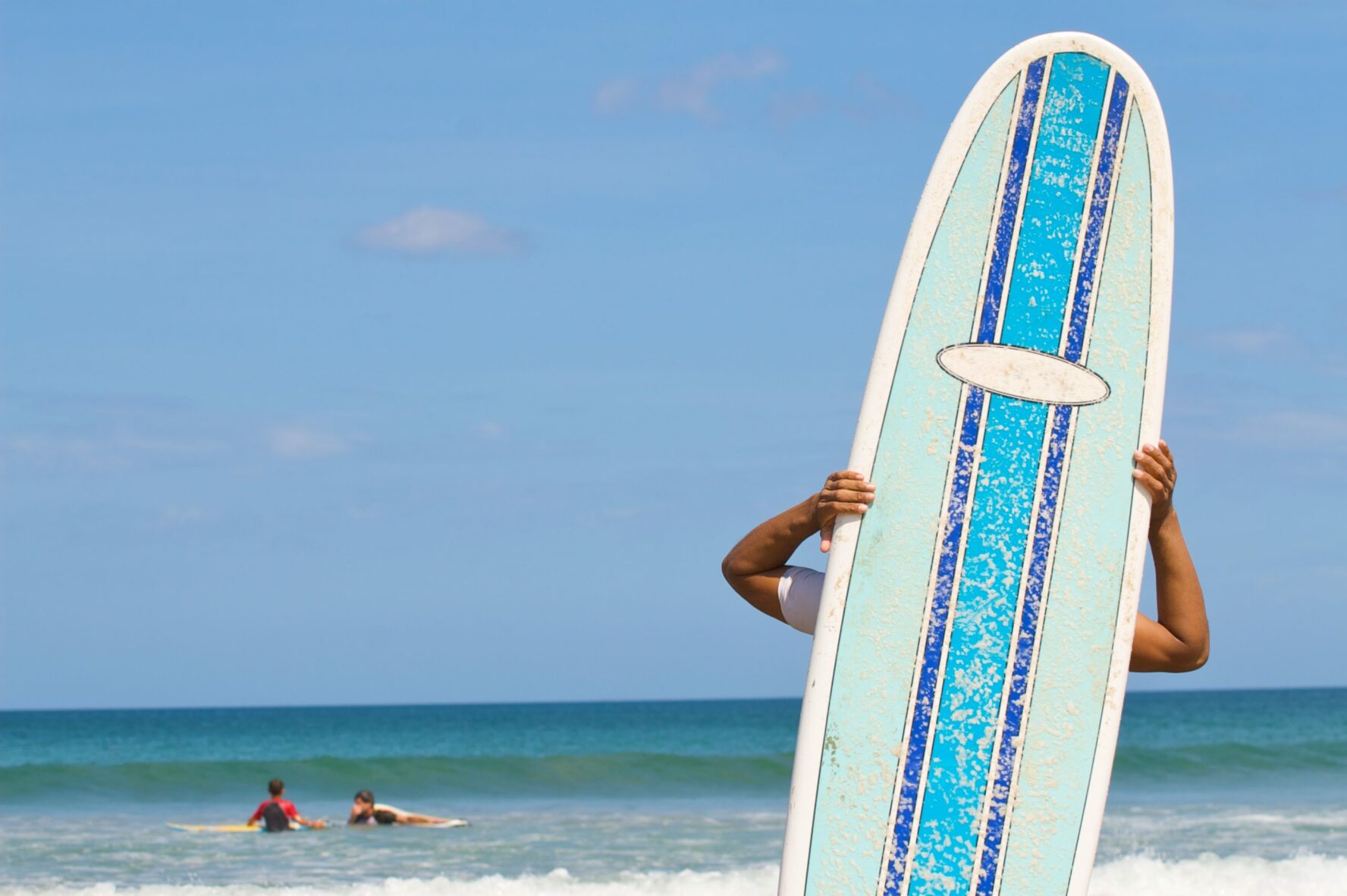 a kid and his surfboard on the beach in tamrindo, Costa rica.
