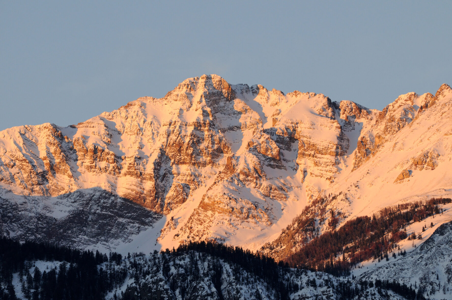 The snow-capped Electric Peak drenched in sunset colors.