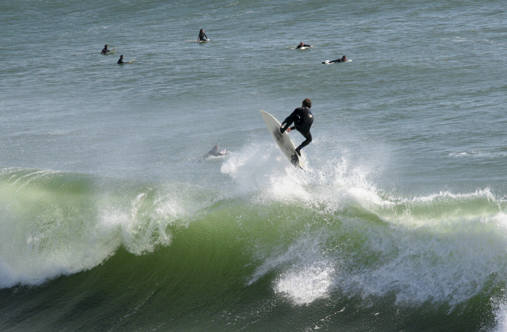 Surfer riding a wave near Lighthouse Field State Beach in Santa Cruz, Ca