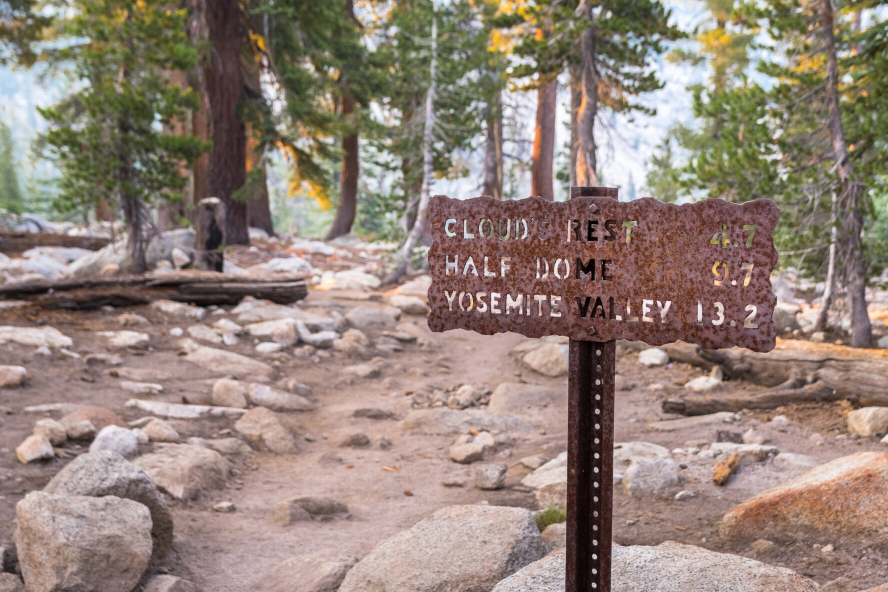 Posted hiking trail sign with the distances in miles to Cloud's Rest, Half Dome and Yosemite Valley, Yosemite National Park, California