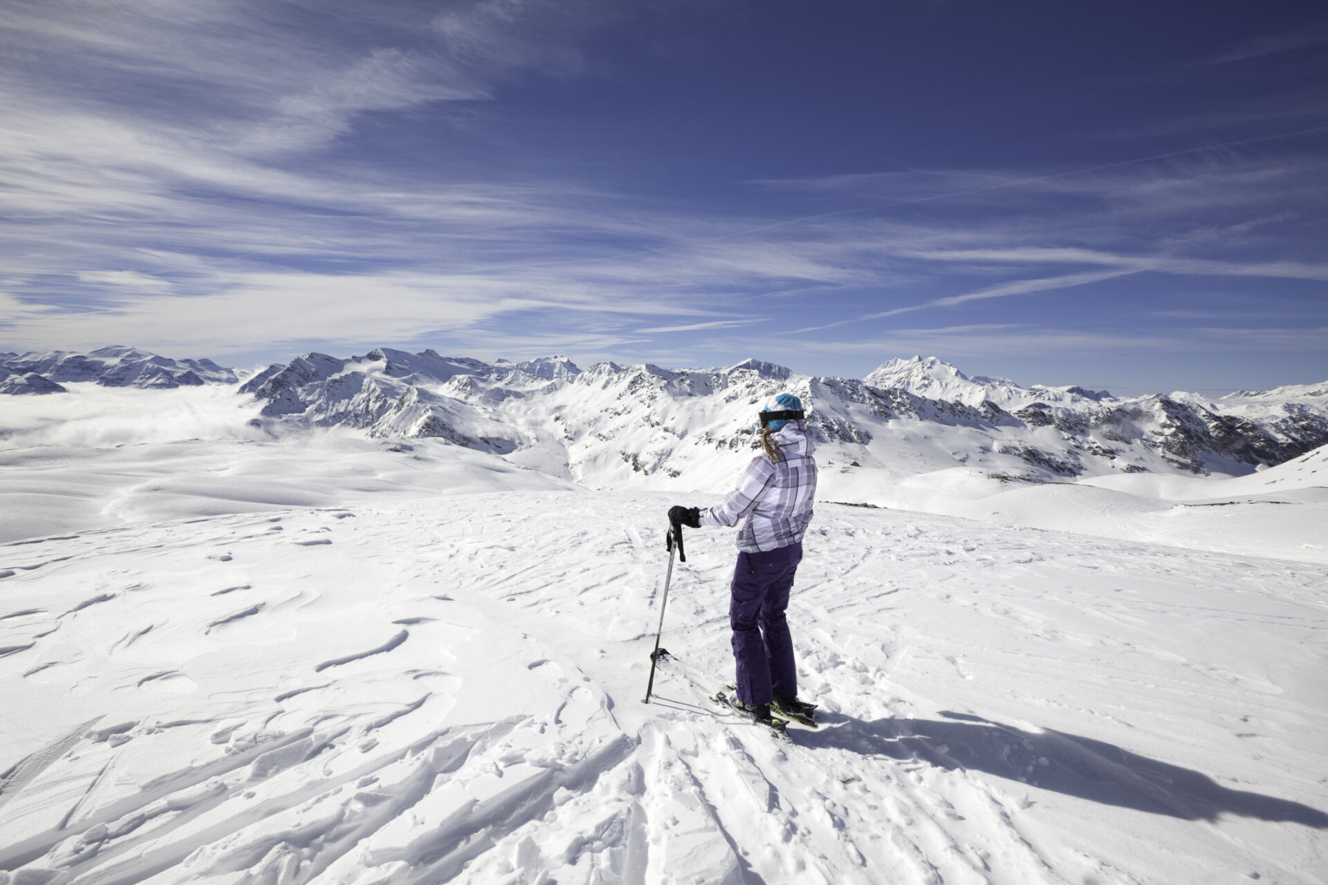 Female skier stopping to appreciate a magnificent view across the French Alps