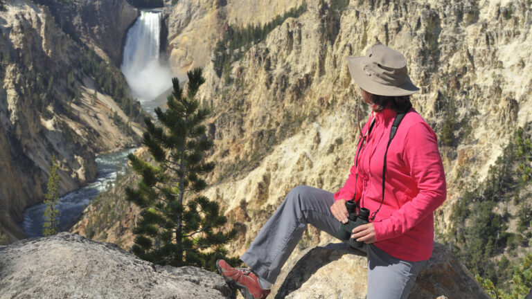 "Woman looking at Lower Falls at Yellowstone National Park, Wyoming, USA."