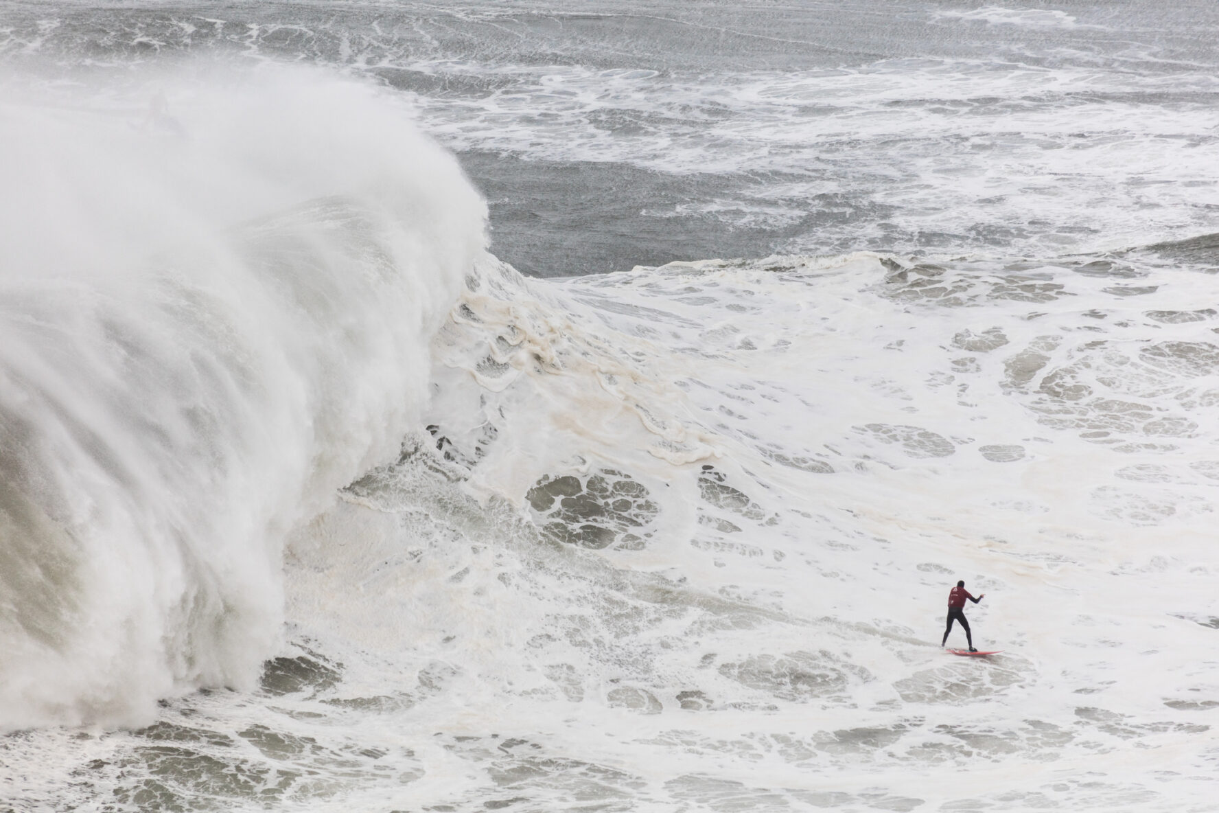 Surfing in giant waves of Nazare, Portugal.