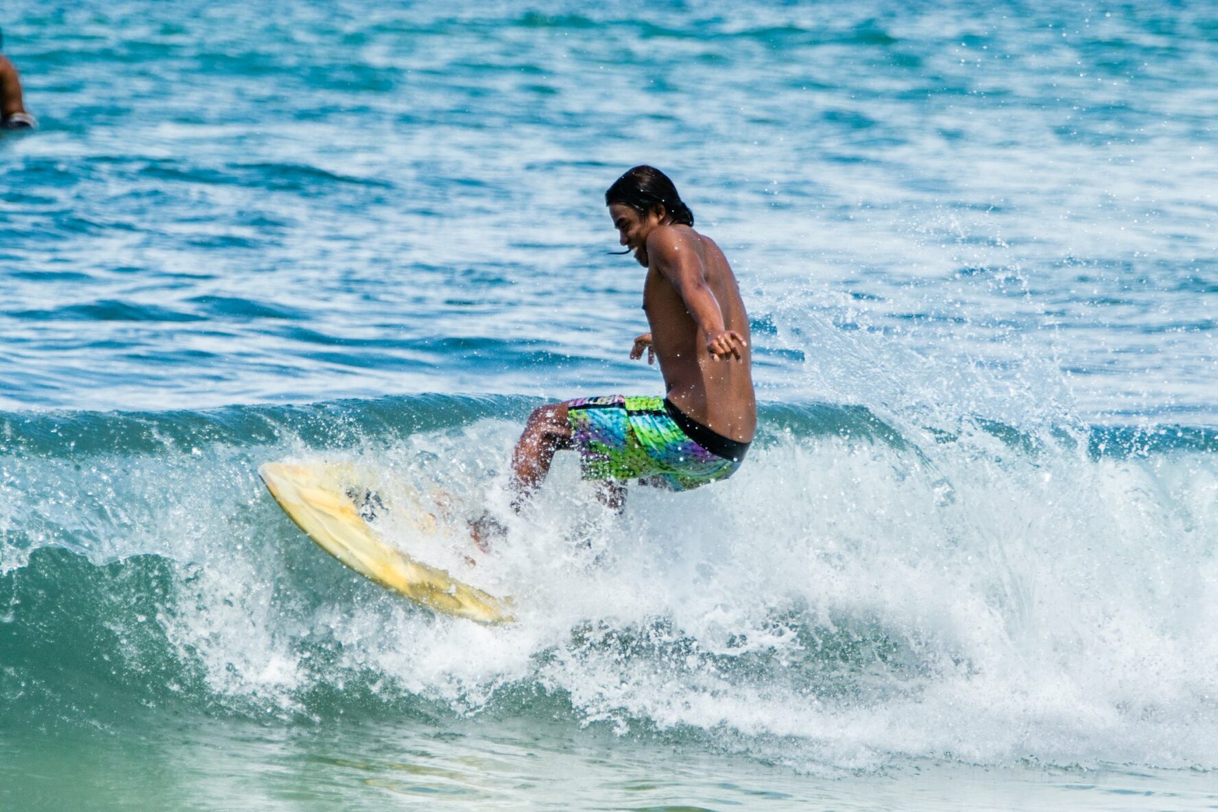 A surfer hitting the wave at Uluwatu.