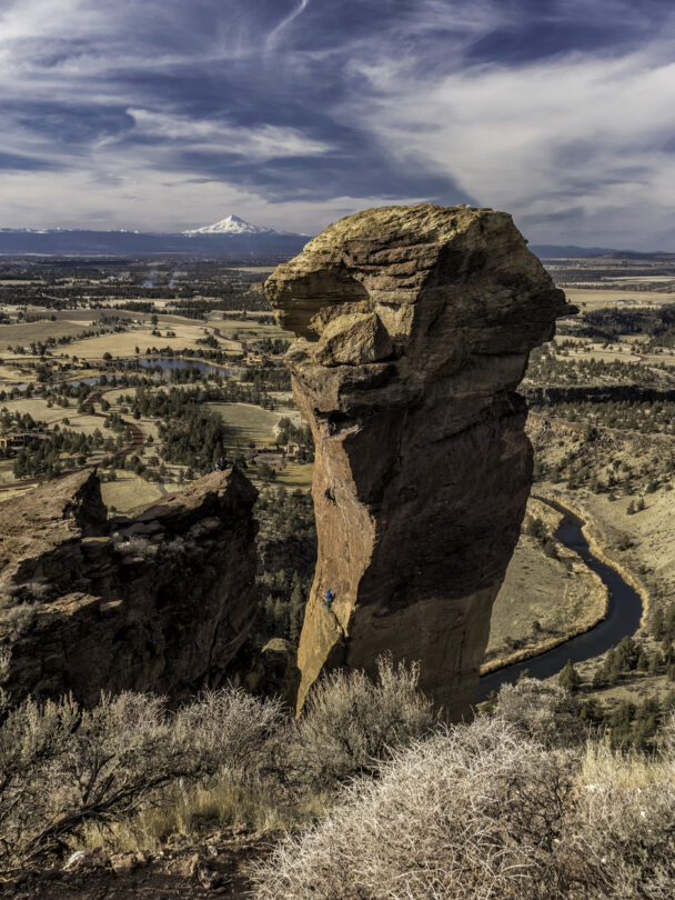 "A woman ascends a cliff at Smith Rock State Park, Oregon."