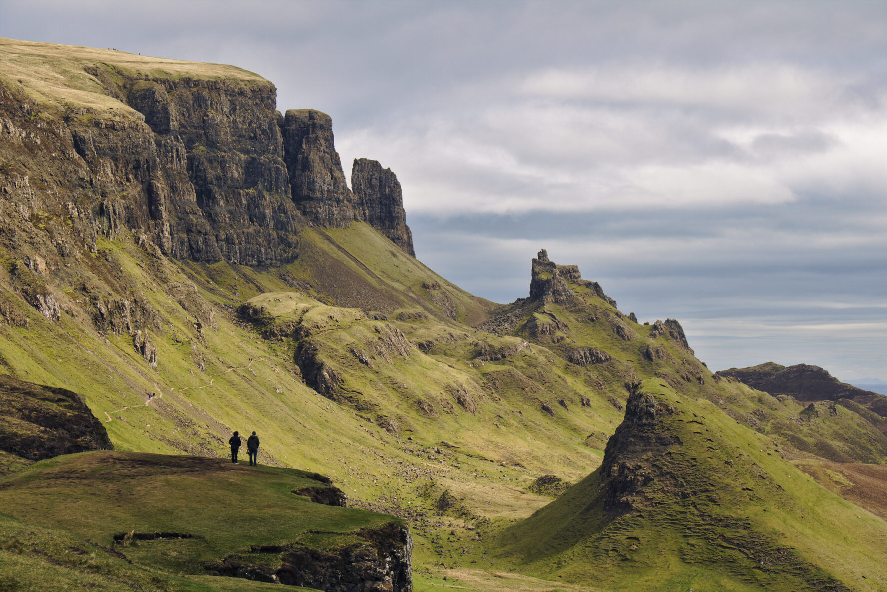 Hikers on the famous Quiraing hiking trail on a cloudy overcast day.