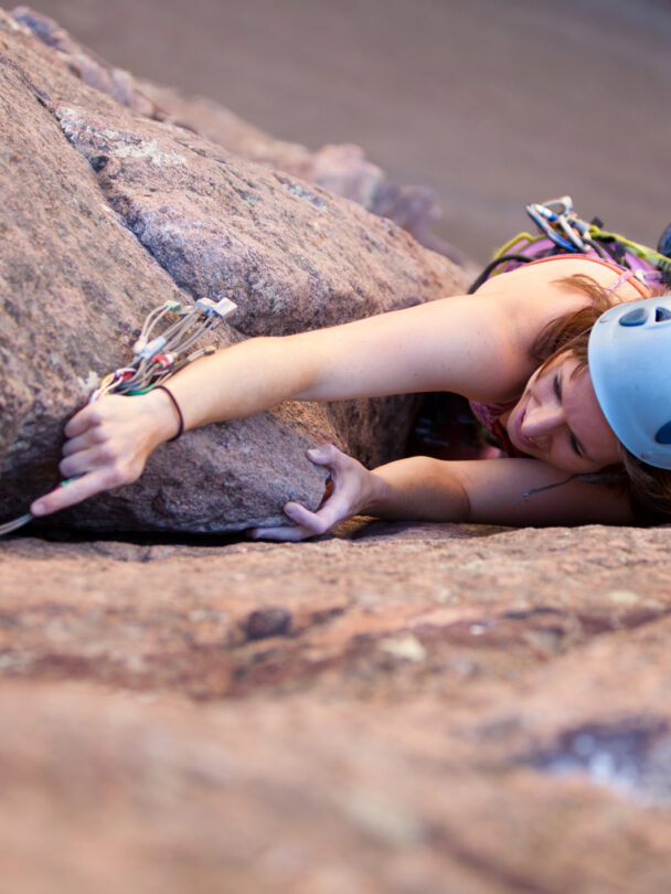 "Female climber makes the traverse from one line to the next on the fourth pitch of Orange Julius - Lumpy Ridge, Rocky Mountain National Park."