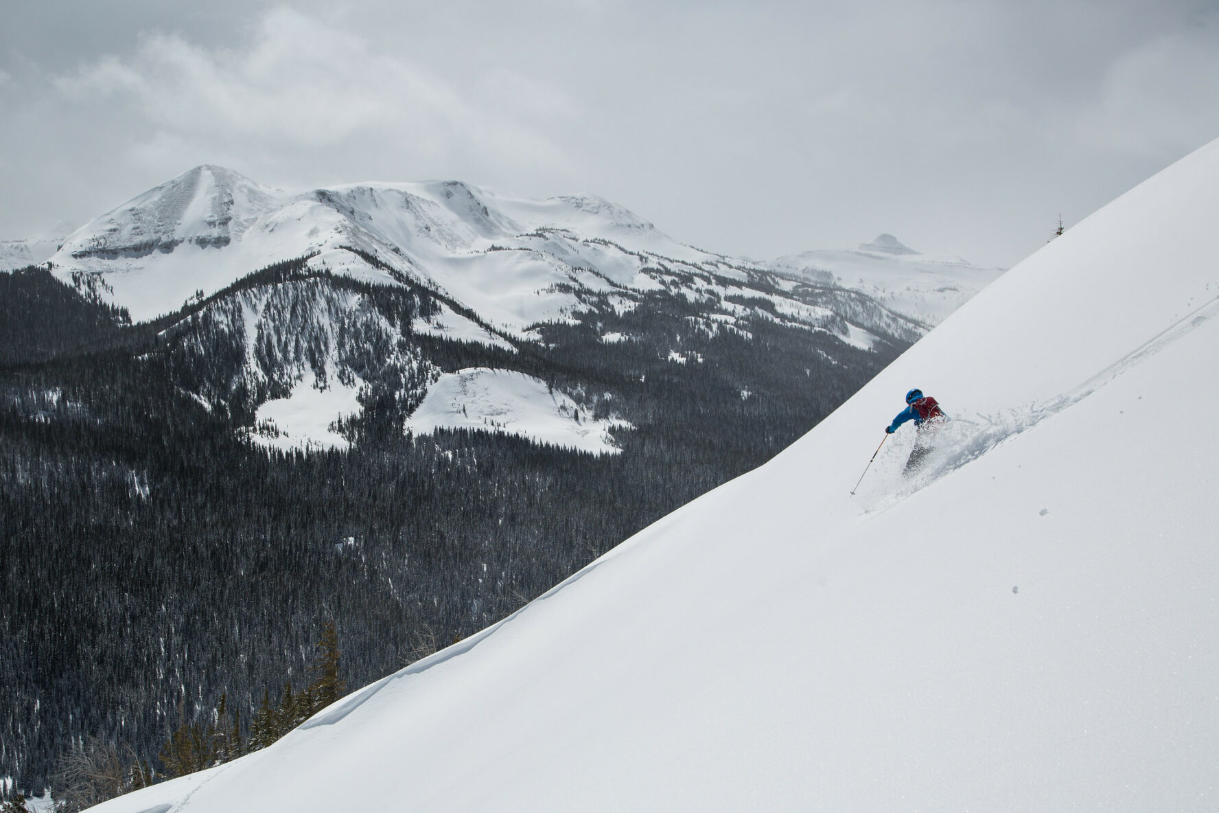 Backcountry skiing on white steep slopes with a guide