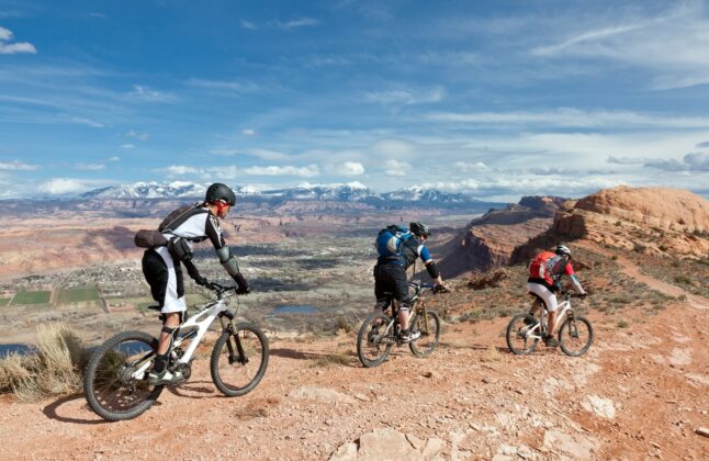 3 people riding a mountain bike in Moab, Utah