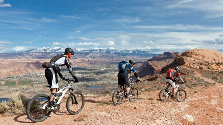 3 people riding a mountain bike in Moab, Utah