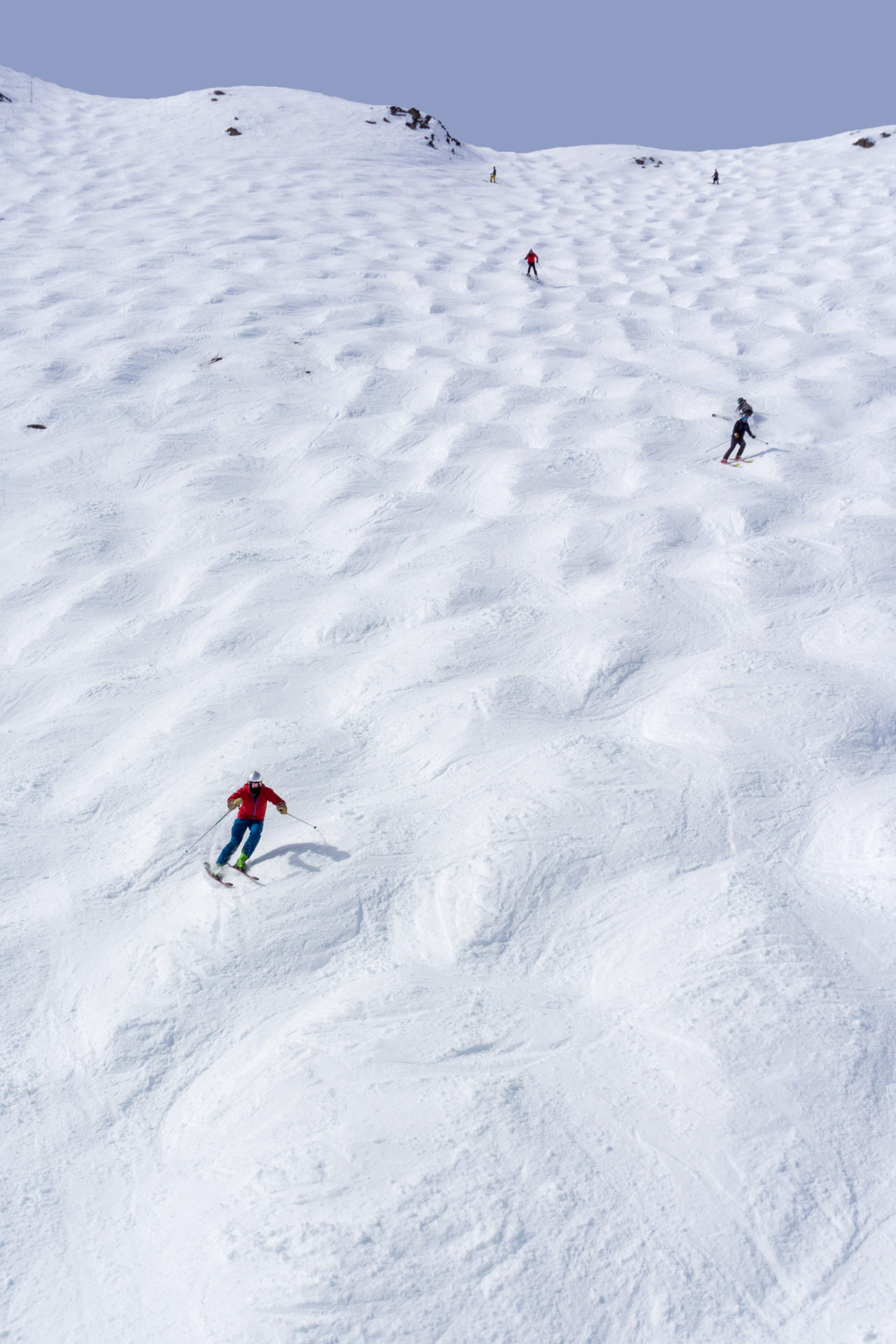 Skiers descending a bumpy slope in Lake Louise