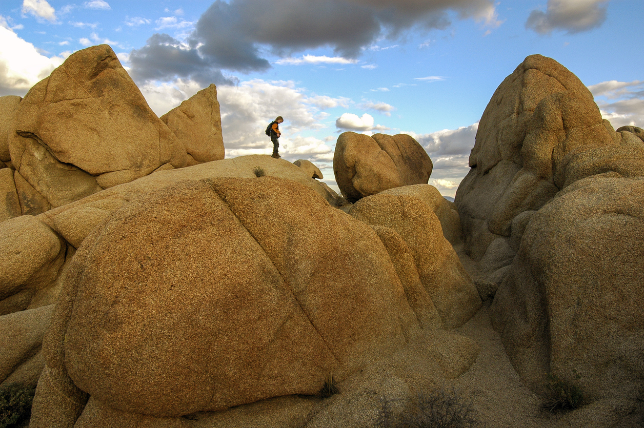 Young boy hiking on boulders at Jumbo Rocks, Joshua Tree National Park, California.