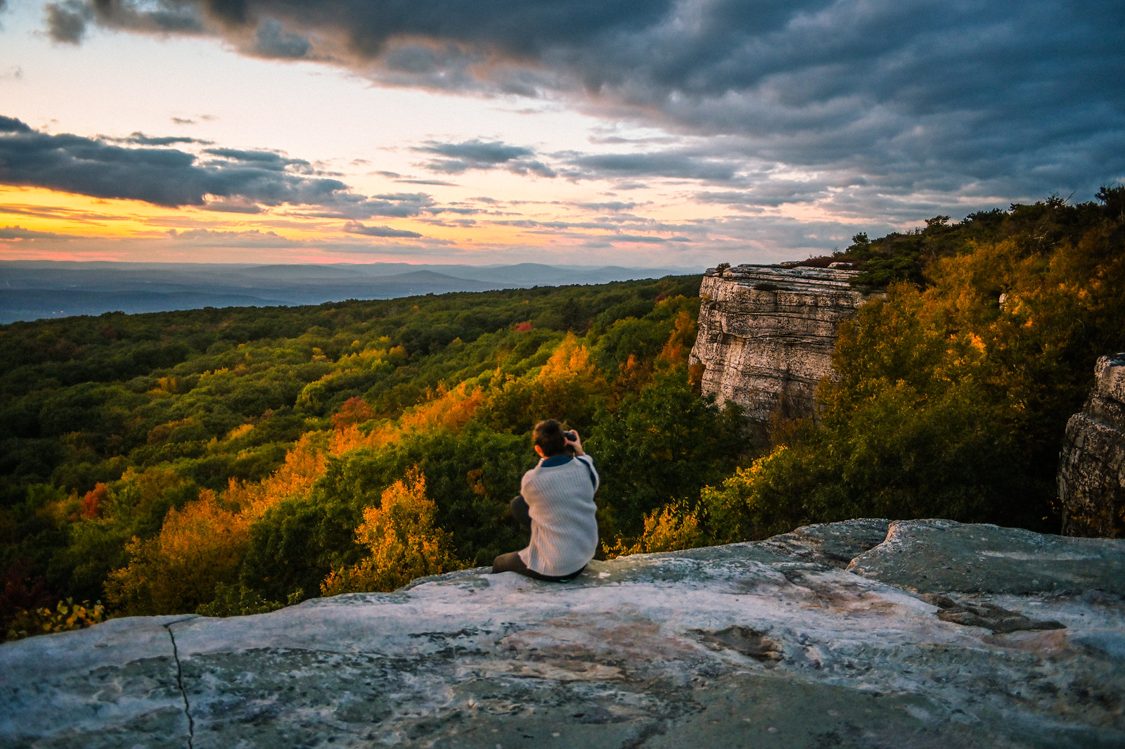 A photographer on a ridge taking photos of the Gunks