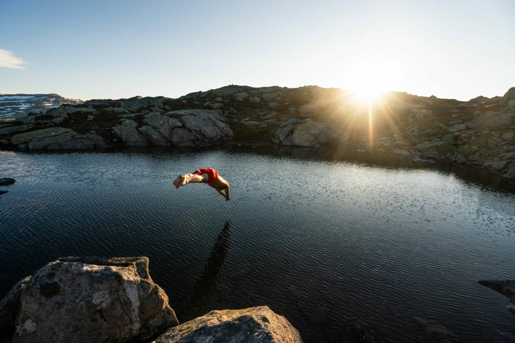 A man diving into a pond near Trolltunga, Norway