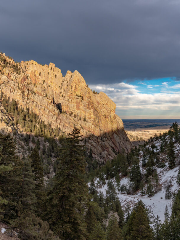 Pair of mountain climbers work together to scale a cliff high in the Colorado Rockies.
