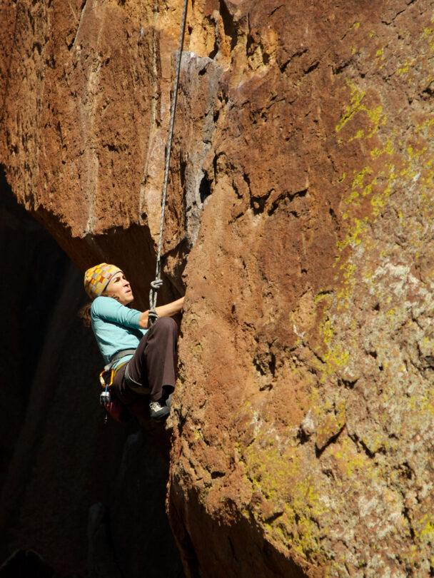 Pair of mountain climbers work together to scale a cliff high in the Colorado Rockies.