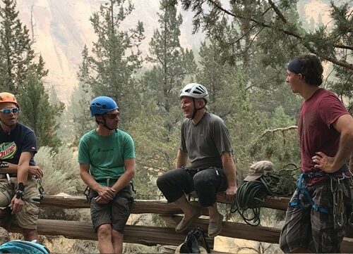 A woman nears the top of a spire at Smith Rock State Park, Oregon. The Crooked River is far below in the valley.