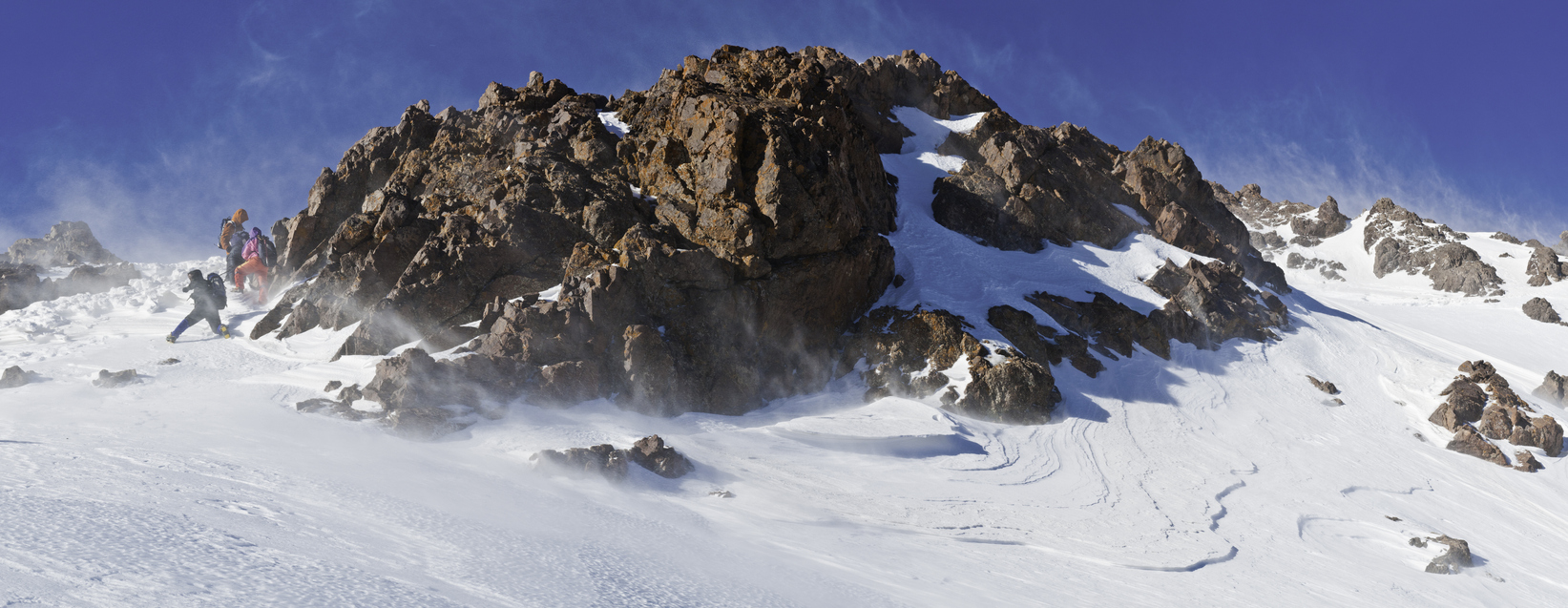 Mountaineering team battling in the strong wind and spindrift snow to climb a high mountain summit in the Atlas Mountains of Morocco, North Africa. ProPhoto RGB profile for maximum color fidelity and gamut.