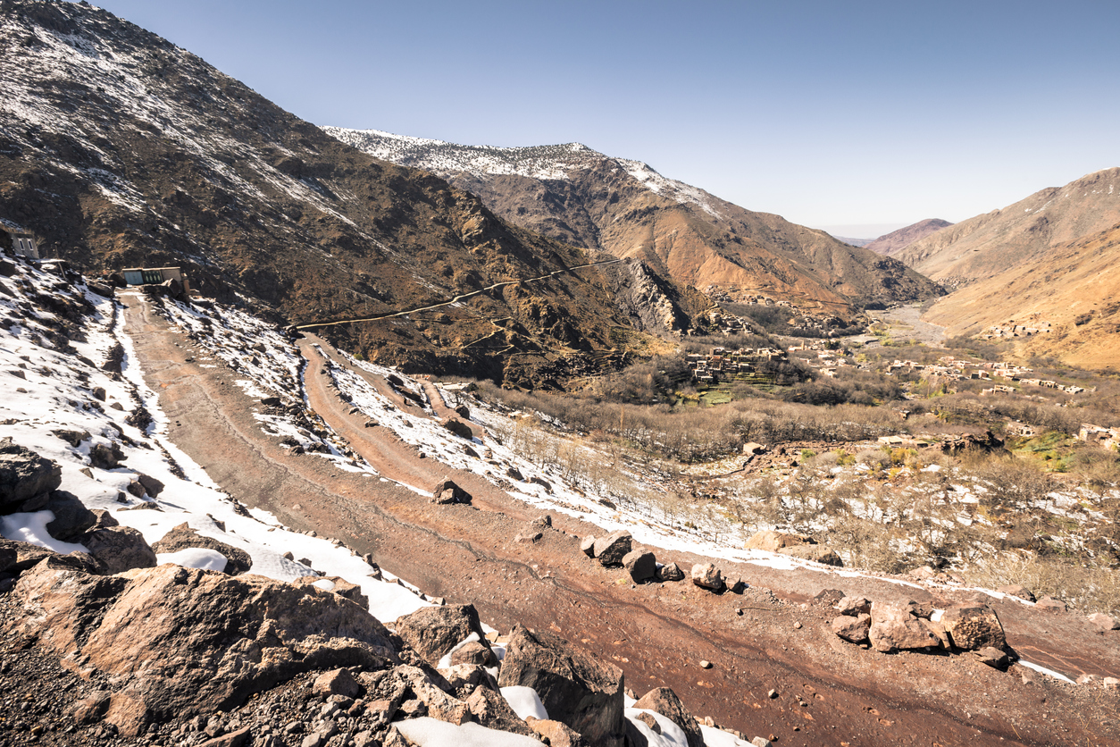 Rocky landscape at the Atlas mountains near Imlil village, Morocco, on sunny day with blue sky showing a winding dirt path