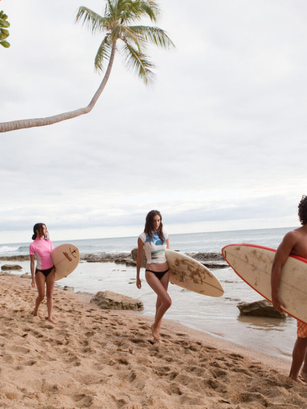 Surfing in Puerto Rico, beach and waves framed by a couple of palm trees