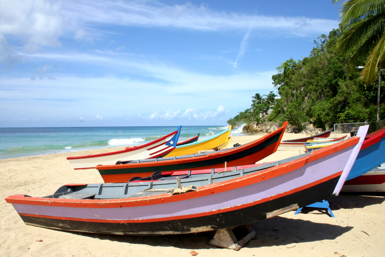 Fishing Boats at Las Playuelas (Crash Boat Beach) in Aguadilla, Puerto Rico (Caribbean). One of the boats has painted on a Puerto Rico's flag. The yellow sand contrats with the blue sky.