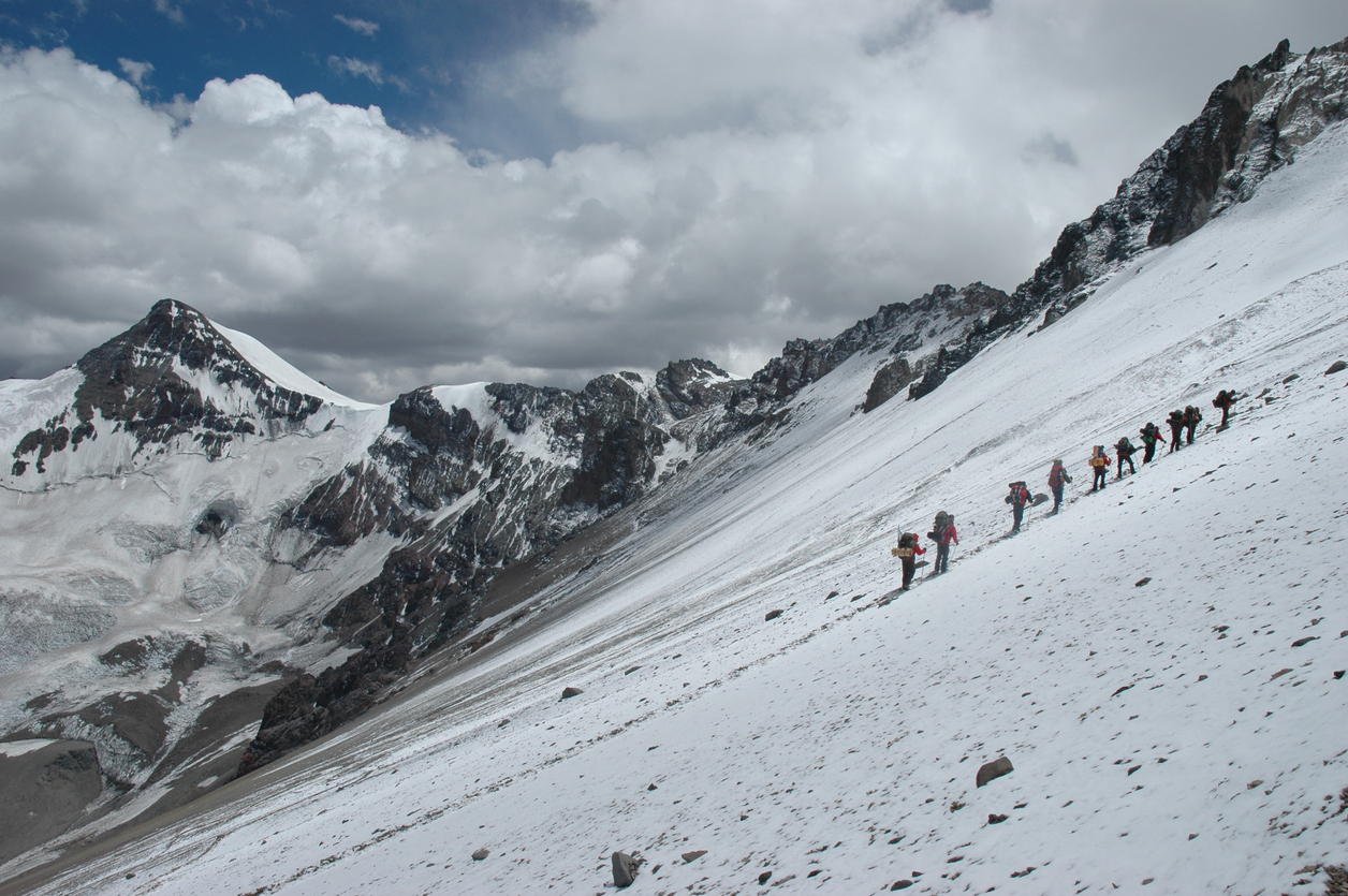 Climbers climbing Aconcagua peak in winter onditions, South America