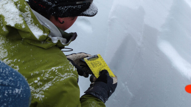 Avalanche Education in Crested Butte, a man measures snow