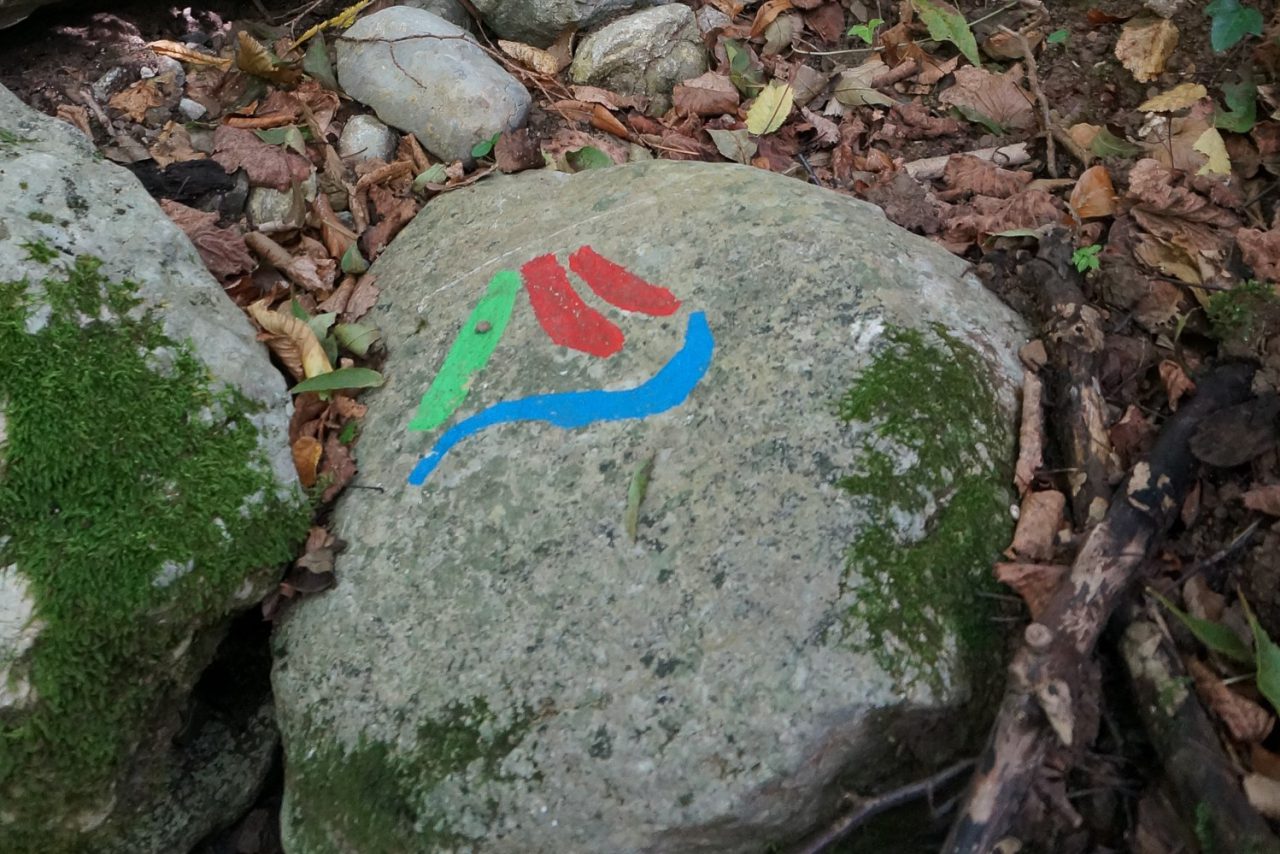 Rock with a colourful symbol on the Alpe Adria Trail