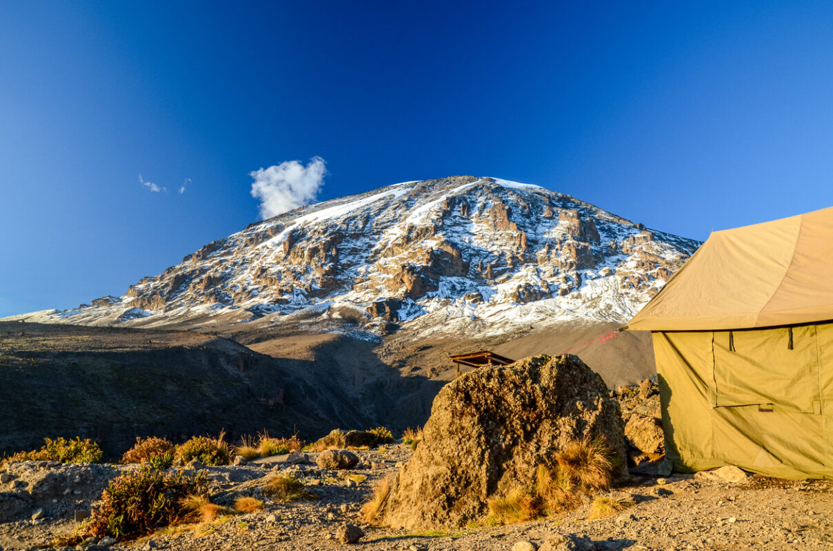 Stunning evening view of Kibo with Uhuru Peak (5895m amsl, highest mountain in Africa) at Mount Kilimanjaro,Kilimanjaro National Park,seen from Karanga Camp at 3995m amsl. Orange tent in foreground.
