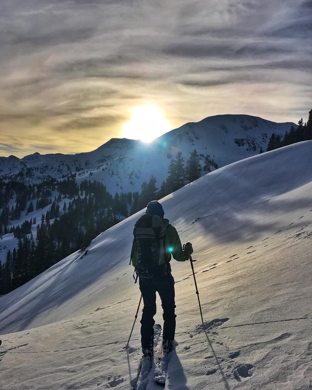 A skier watching a beautiful sunrise from the slopes