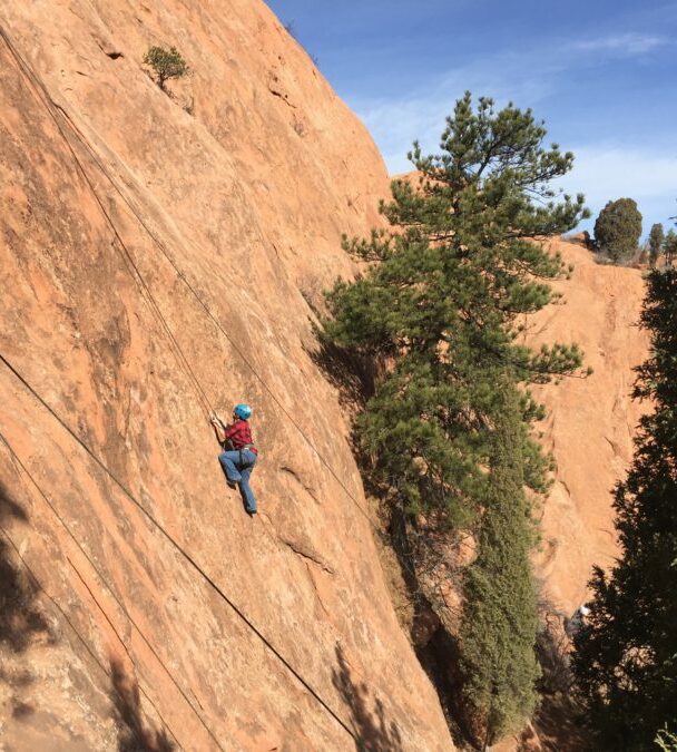 A woman climbing a cliff in Colorado