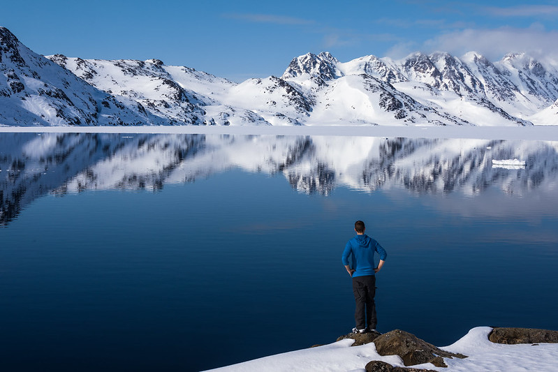 A man in reflection near the sea in Greenland