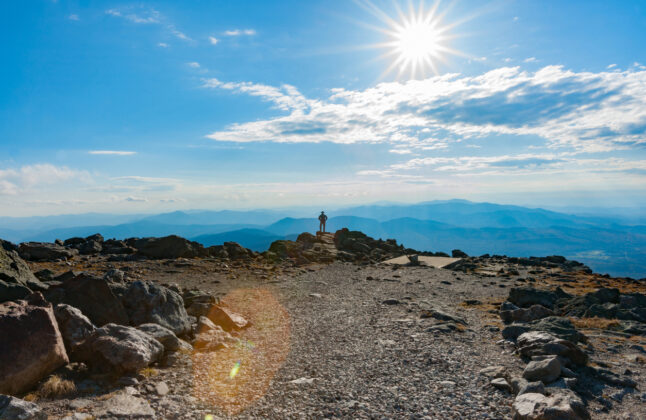 Man standing on the Mount Washington Summit