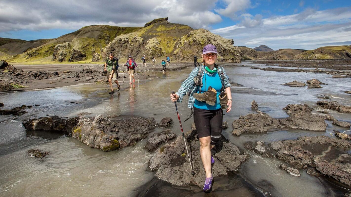 Hikers traversing Iceland’s waters