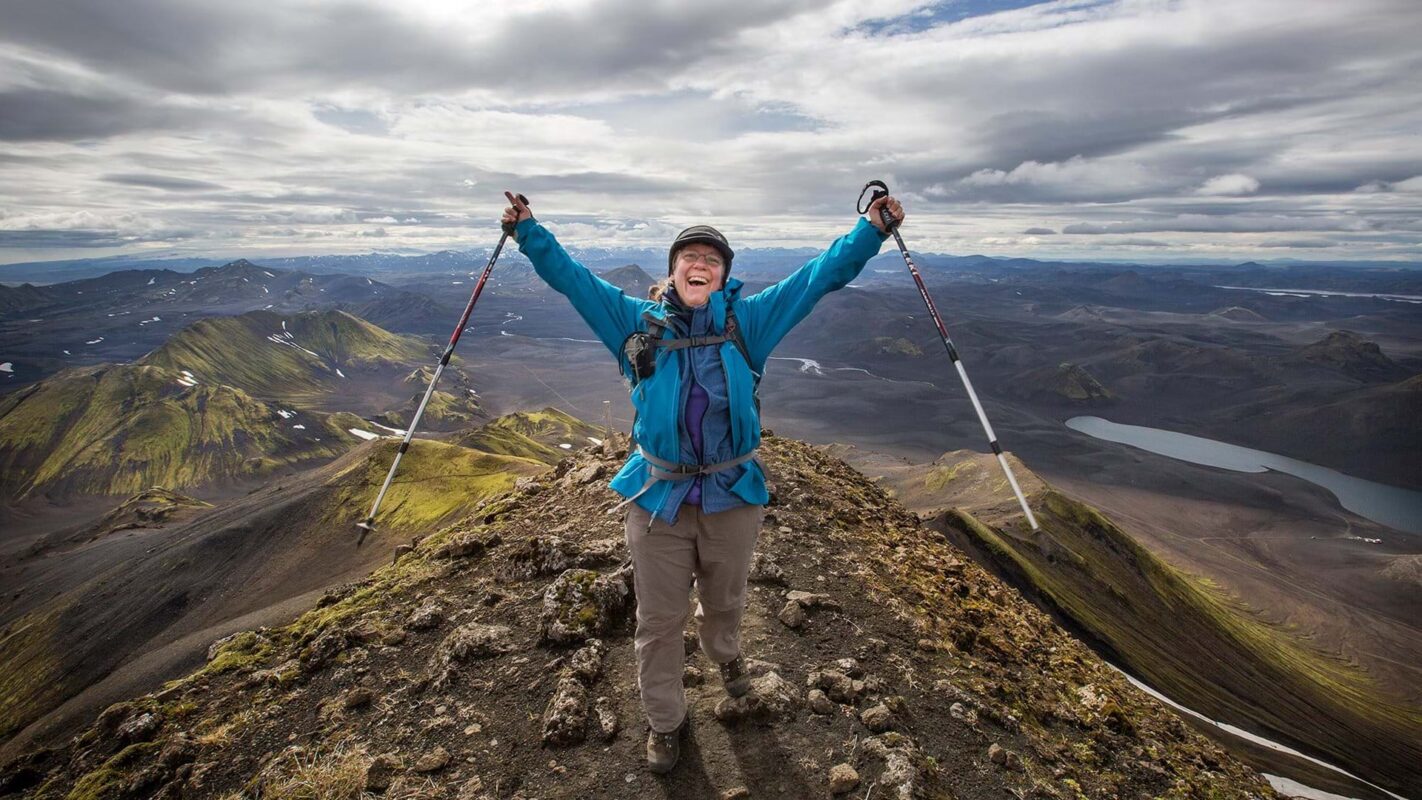 A hiker celebrating a climb on Iceland’s Volcanic Trail