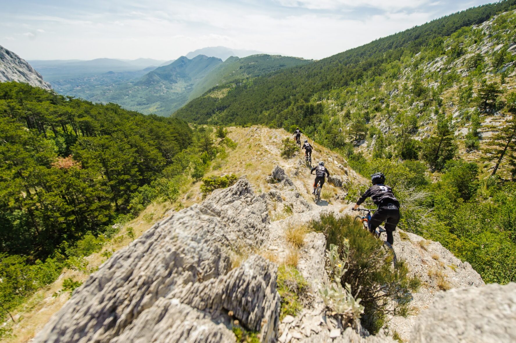 A group of bikers descending a cliff