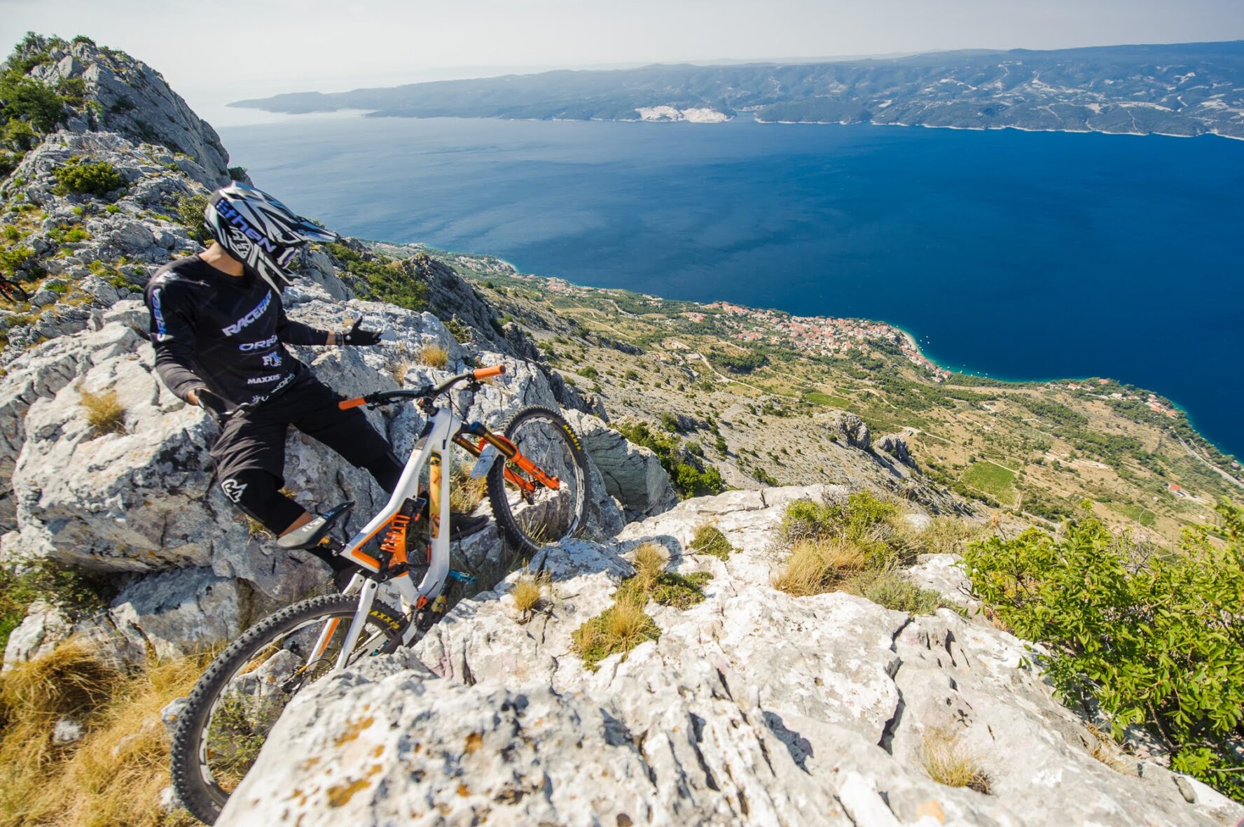 A biker posing on a cliff overlooking the Adriatic Sea