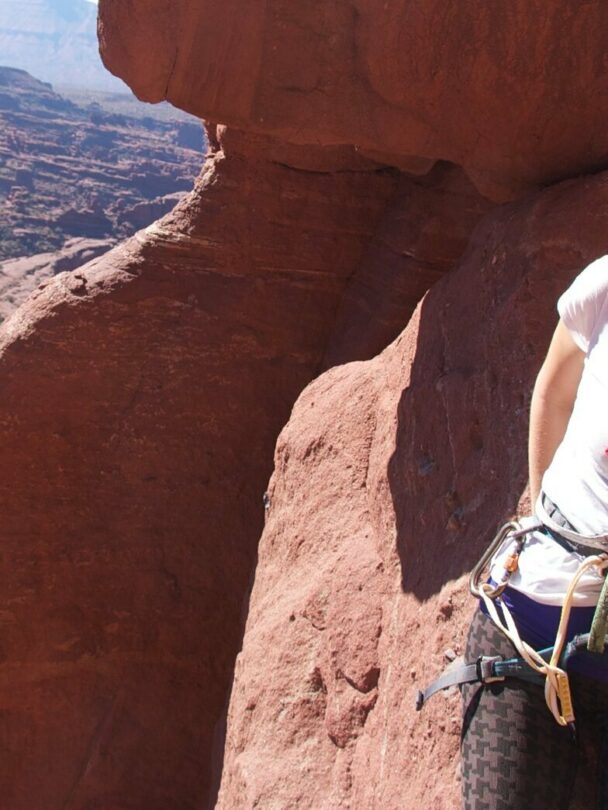 A climber ascending a tower in the Moab region