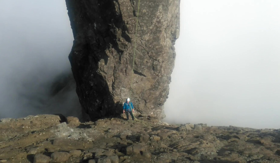 A climber on a cliffside in Cuillin Ridge