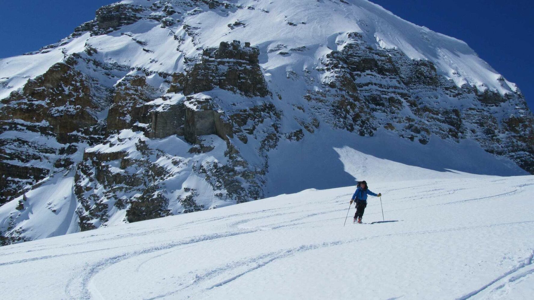 A skier near a peak on the Wapta Traverse