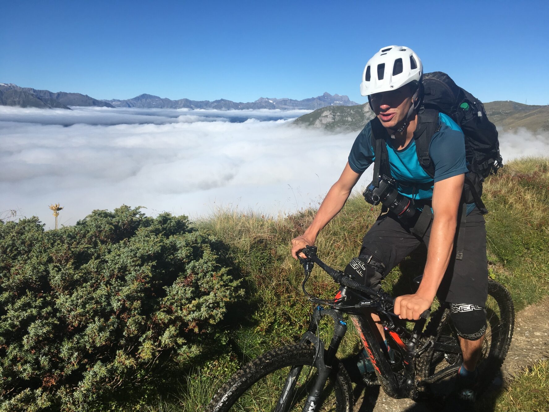 My friend and adventure photographer (often my personal photographer) mountain biking in the Alps above the clouds.