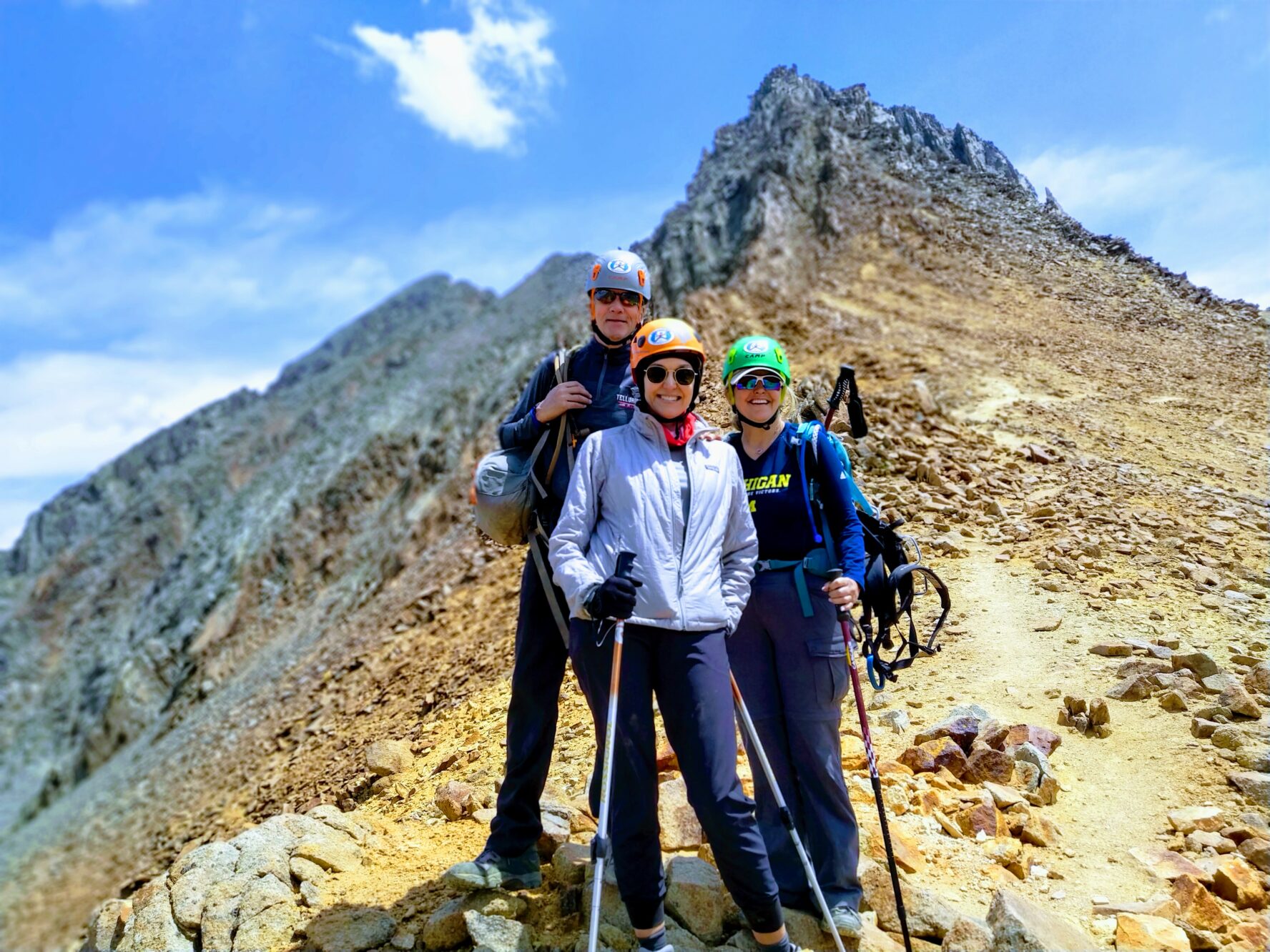 Mountaineers posing victoriously in the San Juan mountains