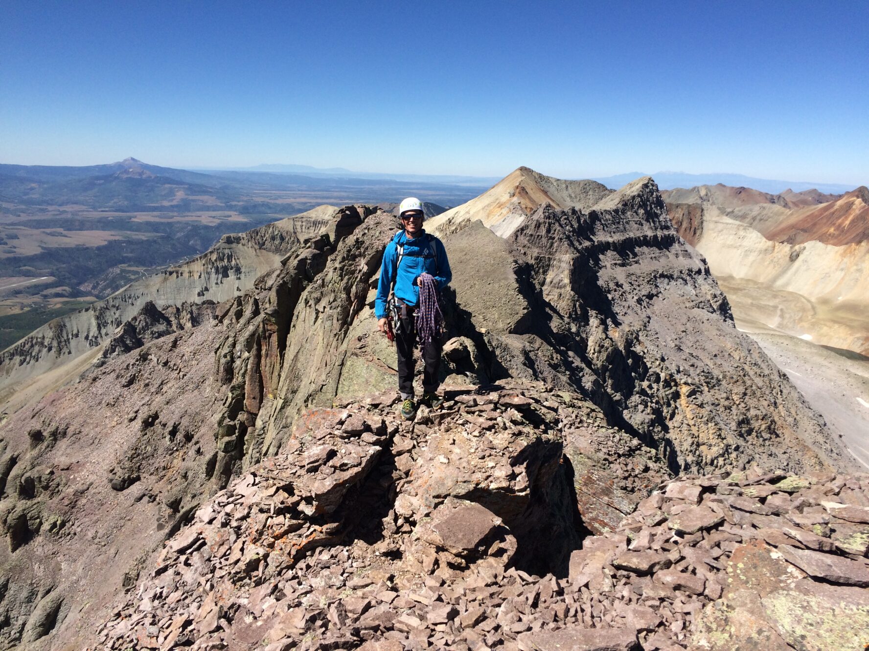 A climber on a peak in the San Juan mountains