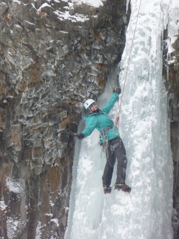 A woman ice climbing in Hyalite Canyon